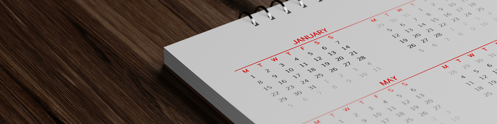 A closeup of a calendar year sitting on a wooden desktop